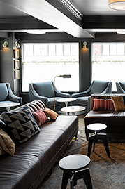 Harley channel-tufted armless sofa in Saloon Dark Brown leather and Martexin Olive waxed canvas at Nouveau Monde Wine Bar