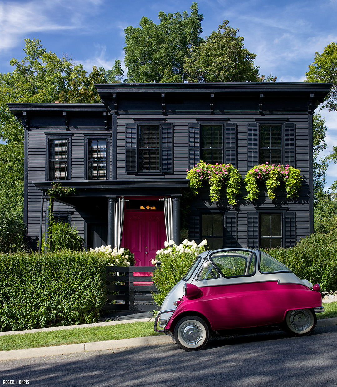 The front of the house with pink doors, window boxes, and a BMW Isetta parked out front.