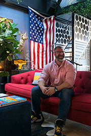 Chris sitting on 96 Olympia sofa in Varick Pomegranate stain-proof red fabric