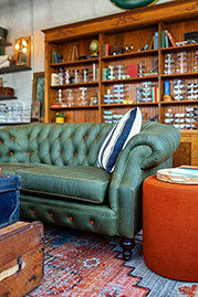 Cecil sofa in Vintage Envy green leather with contrasting orange buttons and orange stitching