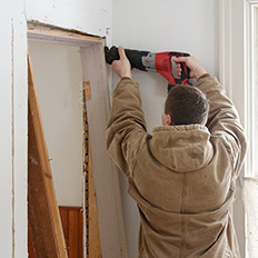 Drew cuts out the old door frame.