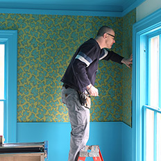 Jim trims paper around the window frame.