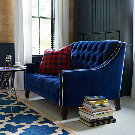 Blue velvet tufted Lincoln loveseat. Photo by Alec Hemer.